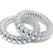 Close up of two silver Curlfection spiral hair ties, against a white background.