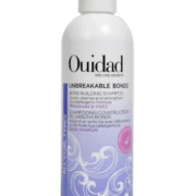 Close-up of a bottle of Ouidad Unbreakable Bonds Bond Building Shampoo against a transparent background.